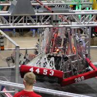 Three robots hang together at the end of a match